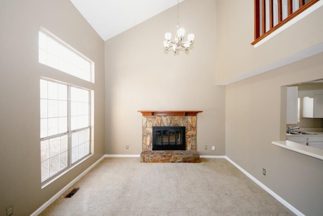 unfurnished living room featuring a stone fireplace, high vaulted ceiling, carpet flooring, sink, and a chandelier