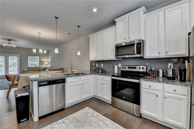 2719 Hedgeway Cir, Kennesaw, GA 30144 - kitchen featuring stainless steel appliances, open floor plan, a peninsula, backsplash, and dark wood-style floors
