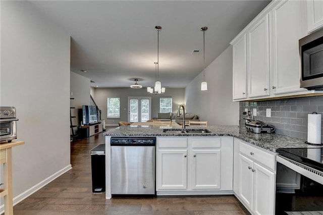 2719 Hedgeway Cir, Kennesaw, GA 30144 - kitchen featuring stainless steel appliances, a peninsula, open floor plan, and dark wood-style flooring
