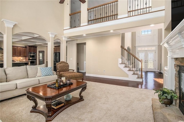 6350 Old Wood Hollow Way, Buford, GA 30518 - living area with ornate columns, a high ceiling, stairs, a ceiling fan, and dark wood-type flooring