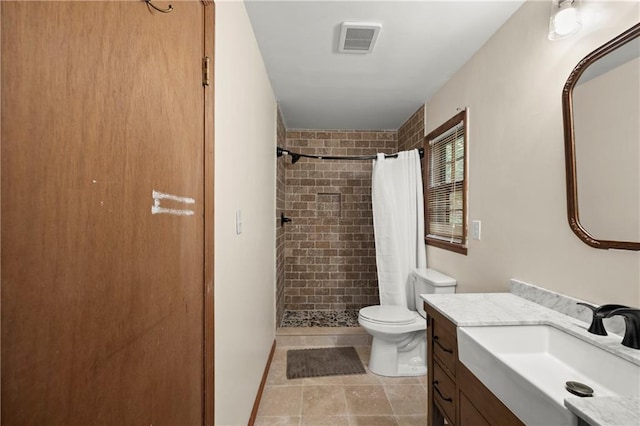 bathroom with vanity, toilet, tiled shower, and visible vents