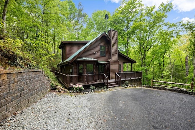 view of front of home featuring covered porch and a chimney