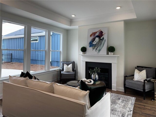 living room featuring a healthy amount of sunlight, ornamental molding, and a tiled fireplace