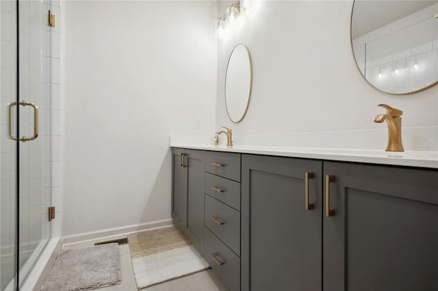 bathroom with double vanity, visible vents, a shower stall, and a sink