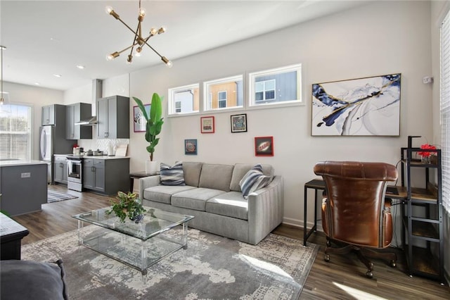 living area with dark wood finished floors, a notable chandelier, and recessed lighting