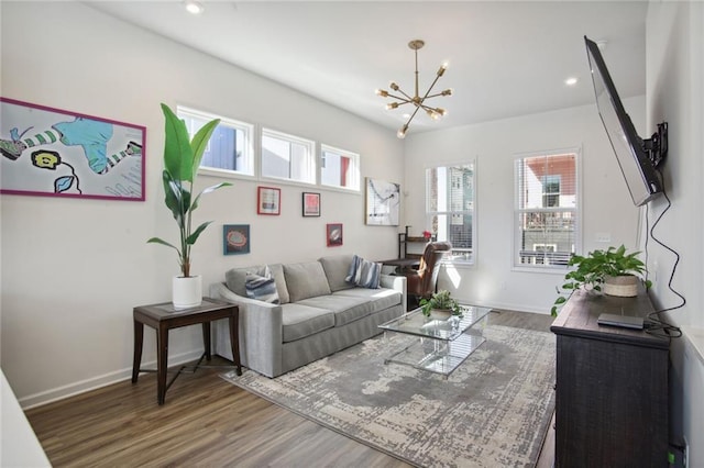 living room featuring a notable chandelier, recessed lighting, baseboards, and wood finished floors