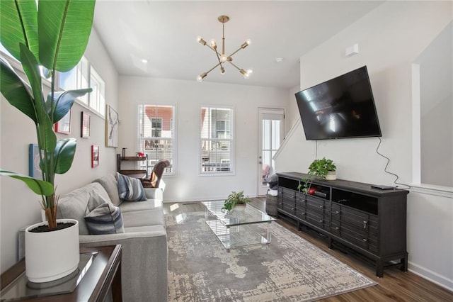 living room with wood finished floors, baseboards, and a chandelier