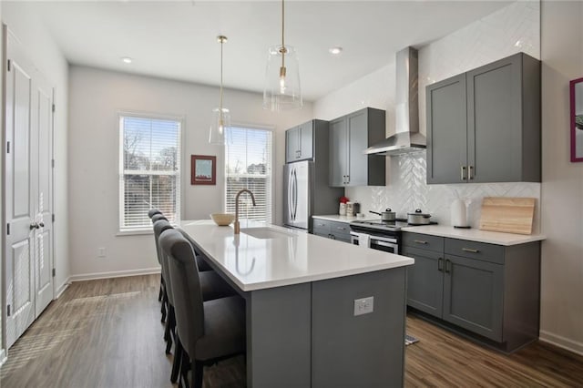 kitchen featuring electric range, gray cabinets, wall chimney exhaust hood, and a sink