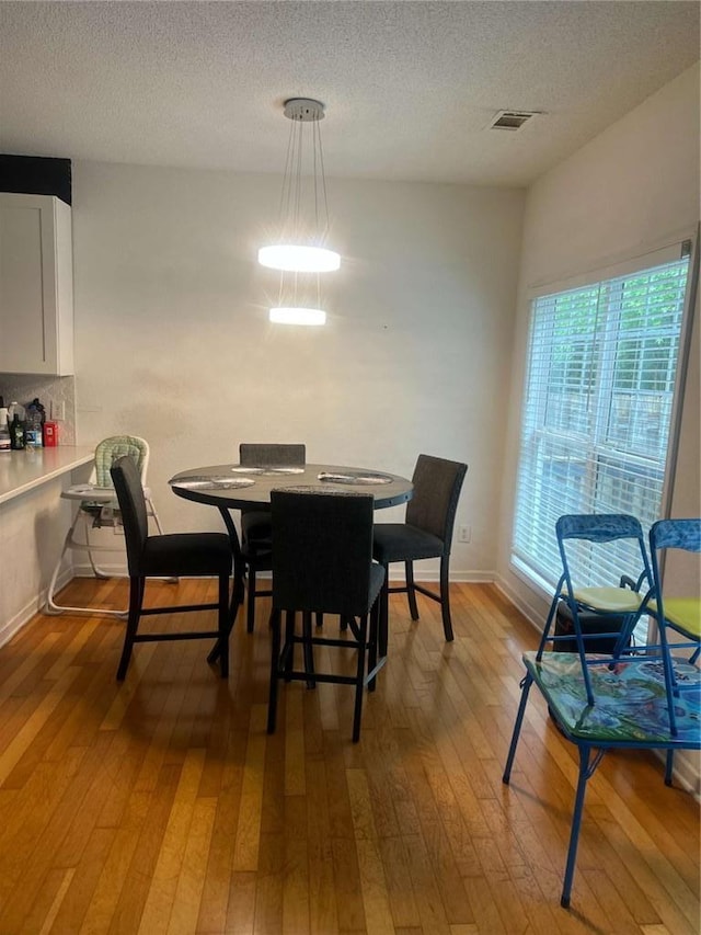 116 Madeline Ct, Mcdonough, GA 30253 - dining area with hardwood / wood-style flooring, a textured ceiling, and baseboards