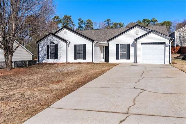 ranch-style home featuring a garage, driveway, a shingled roof, and fence