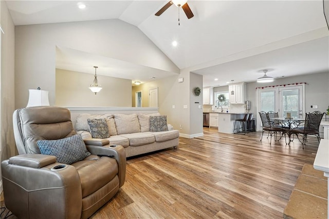 living room with vaulted ceiling, ceiling fan, sink, and light hardwood / wood-style floors