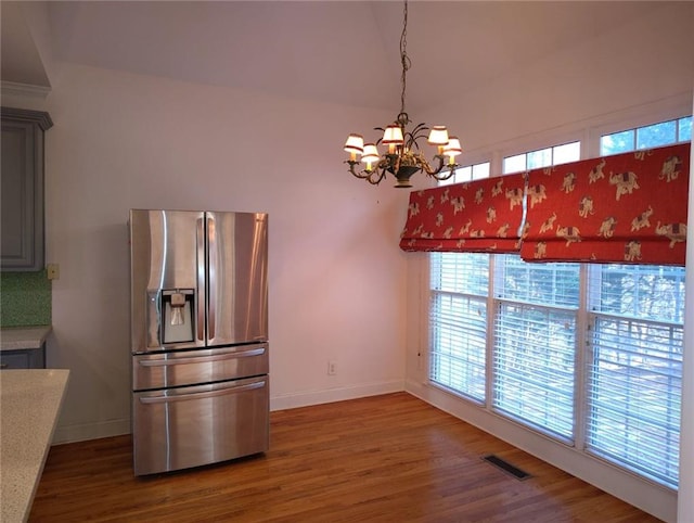 kitchen with visible vents, wood finished floors, stainless steel fridge with ice dispenser, and light countertops