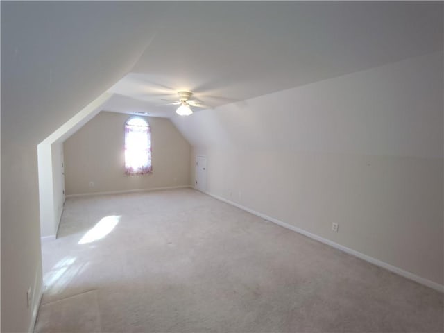 bonus room featuring baseboards, light carpet, ceiling fan, and vaulted ceiling