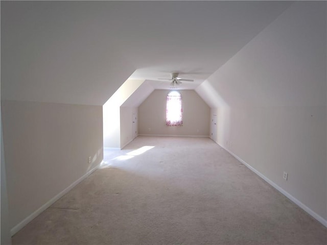 additional living space featuring a ceiling fan, lofted ceiling, light colored carpet, and baseboards