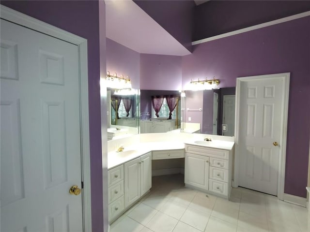 full bath featuring double vanity, tile patterned floors, and a sink