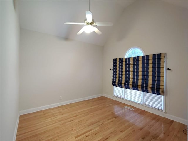 empty room with visible vents, a ceiling fan, baseboards, and wood finished floors