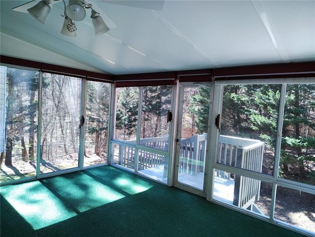 unfurnished sunroom featuring ceiling fan and vaulted ceiling