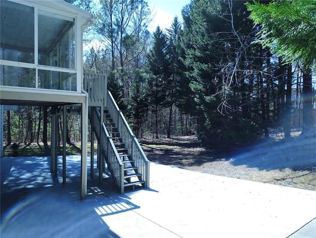 view of yard with a patio area, stairs, and a sunroom