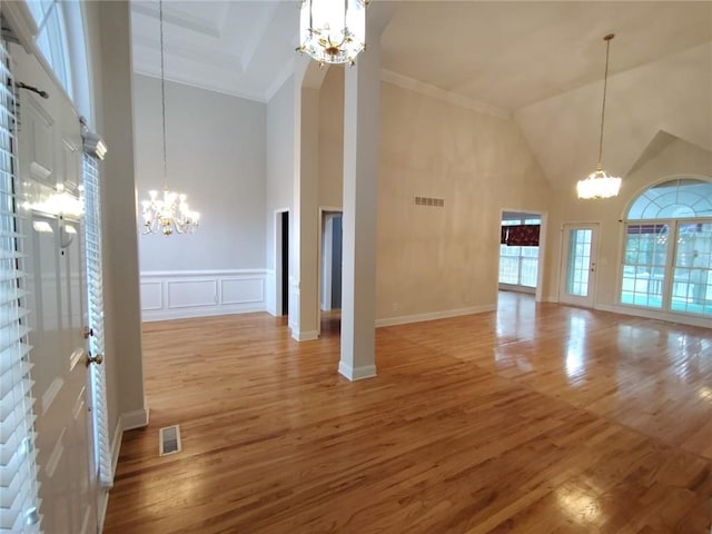 unfurnished living room featuring a notable chandelier, visible vents, and a wealth of natural light