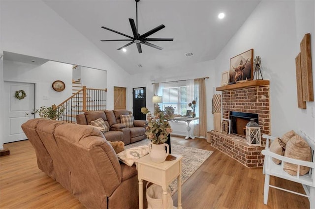 3088 Hiram Sudie Rd, Hiram, GA 30141 - living room featuring ceiling fan, stairs, light wood-style floors, a brick fireplace, and high vaulted ceiling