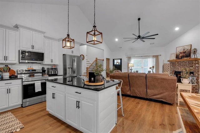 3088 Hiram Sudie Rd, Hiram, GA 30141 - kitchen featuring appliances with stainless steel finishes, high vaulted ceiling, dark countertops, ceiling fan, and a kitchen island
