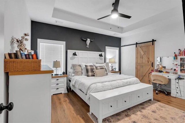 3088 Hiram Sudie Rd, Hiram, GA 30141 - bedroom with a raised ceiling, a barn door, wood finished floors, and ceiling fan