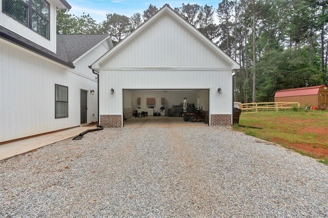 3088 Hiram Sudie Rd, Hiram, GA 30141 - view of home's exterior featuring gravel driveway, a garage, an outbuilding, a shingled roof, and brick siding
