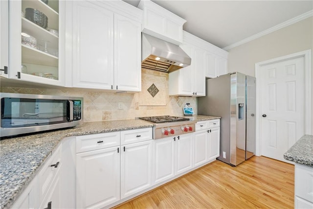 420 Big Bend Trl, Sugar Hill, GA 30518 - kitchen featuring appliances with stainless steel finishes, ornamental molding, wall chimney range hood, white cabinets, and glass insert cabinets