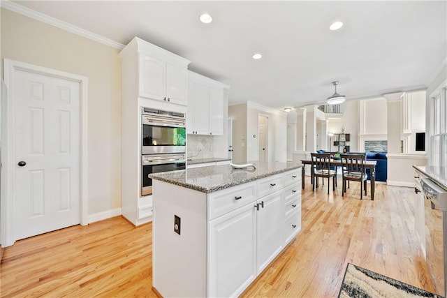 420 Big Bend Trl, Sugar Hill, GA 30518 - kitchen with stainless steel appliances, ornamental molding, white cabinets, light wood-style flooring, and a kitchen island
