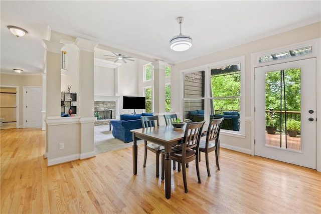 420 Big Bend Trl, Sugar Hill, GA 30518 - dining room featuring light wood-style floors, a stone fireplace, crown molding, ceiling fan, and baseboards