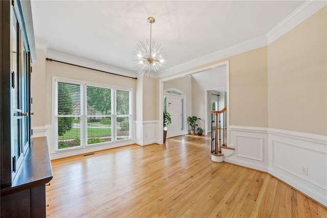420 Big Bend Trl, Sugar Hill, GA 30518 - unfurnished room with a chandelier, light wood finished floors, crown molding, a wainscoted wall, and a decorative wall