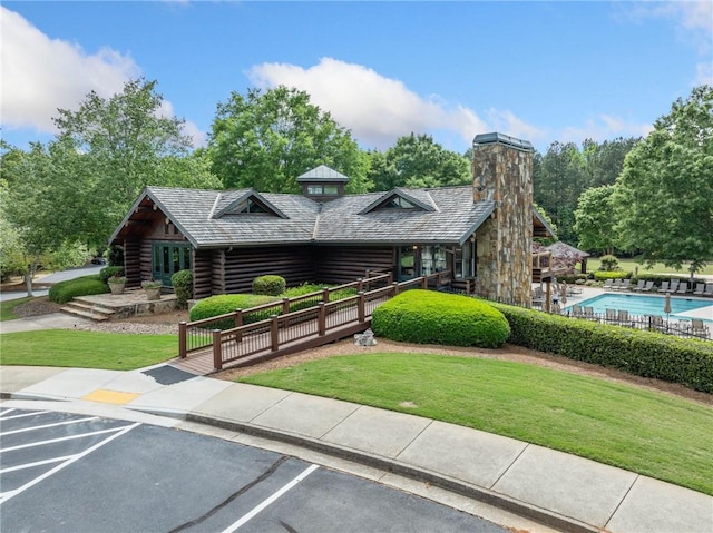 420 Big Bend Trl, Sugar Hill, GA 30518 - view of front of home with log siding, a chimney, a front lawn, and uncovered parking
