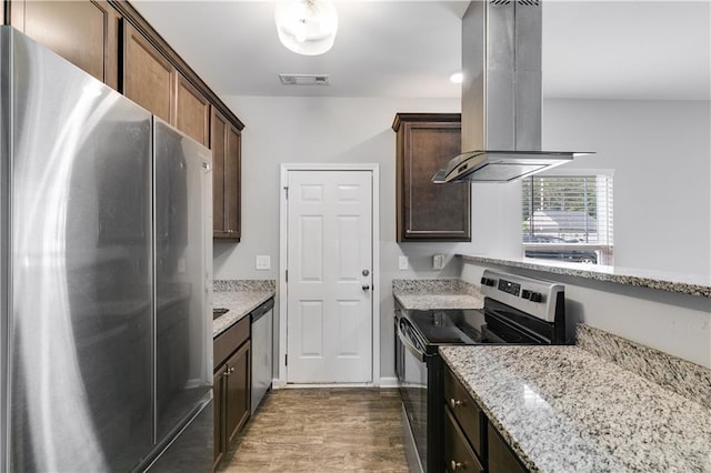 110 Chalfont Cir, Carrollton, GA 30117 - kitchen with stainless steel appliances, island exhaust hood, dark wood-style flooring, light stone counters, and dark brown cabinetry