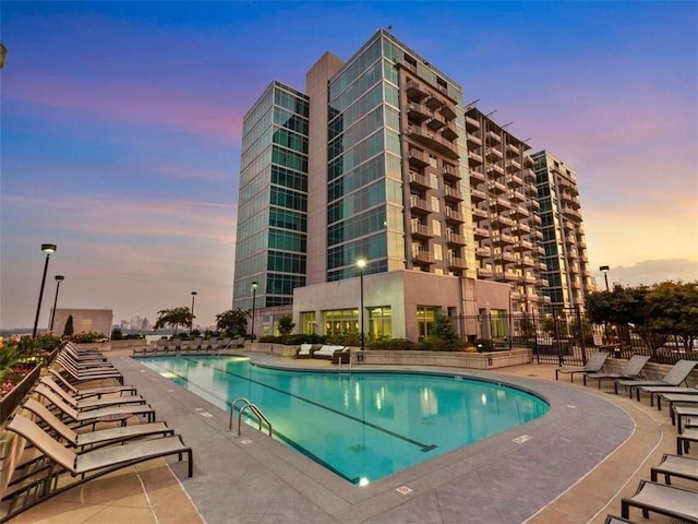 pool at dusk featuring a patio area