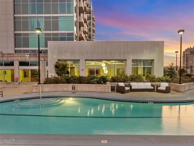 pool at dusk with a patio area