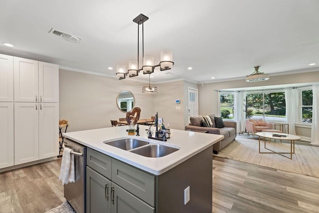 kitchen with visible vents, open floor plan, light countertops, stainless steel dishwasher, and decorative light fixtures