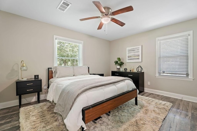 bedroom featuring baseboards, visible vents, ceiling fan, and dark wood-type flooring