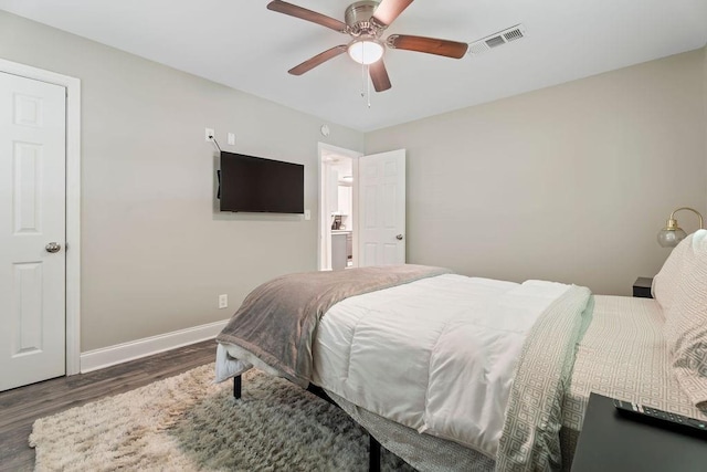 bedroom with dark wood-style floors, visible vents, ceiling fan, and baseboards