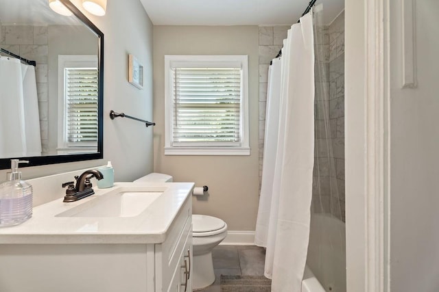 full bathroom featuring tile patterned flooring, toilet, vanity, baseboards, and shower / bath combo with shower curtain