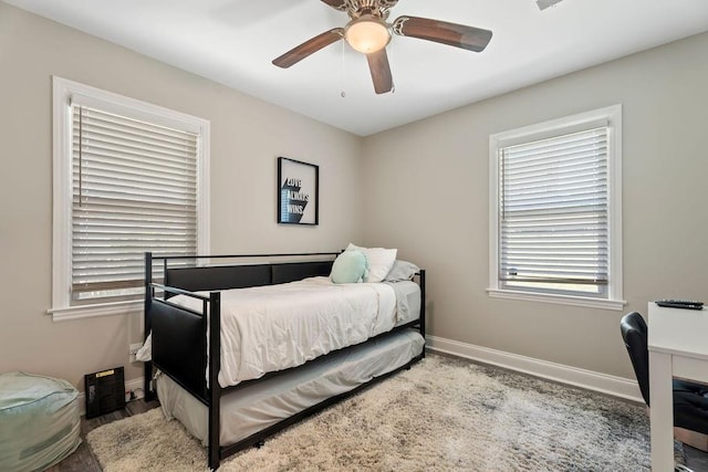 bedroom with a ceiling fan, light wood-style flooring, and baseboards