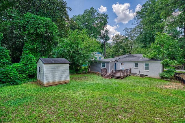 view of yard featuring an outbuilding, a wooden deck, and a storage unit