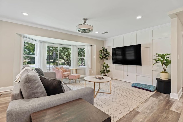 living area with visible vents, baseboards, ornamental molding, light wood-type flooring, and recessed lighting