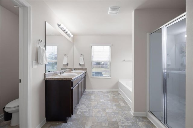 full bathroom with plus walk in shower, plenty of natural light, vanity, and toilet