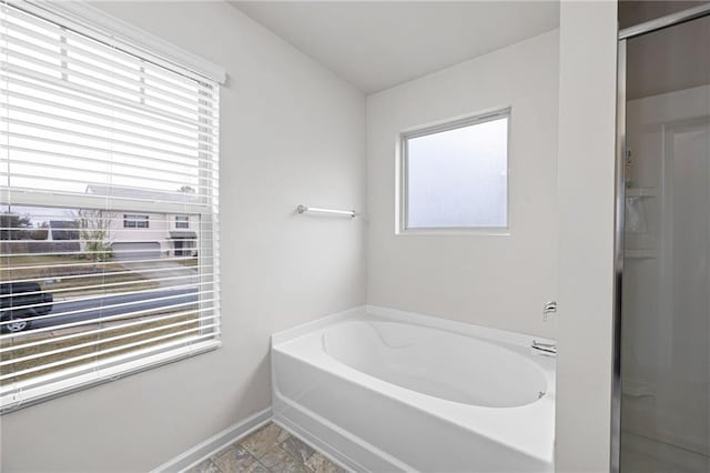 bathroom featuring a wealth of natural light and independent shower and bath