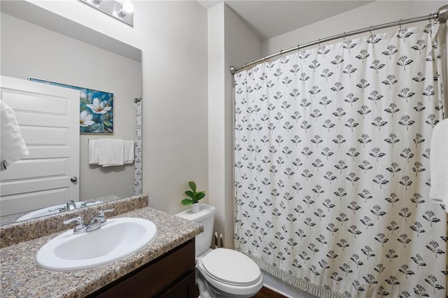 bathroom with curtained shower, vanity, and toilet