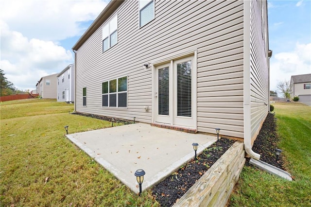 rear view of house with a lawn and a patio area