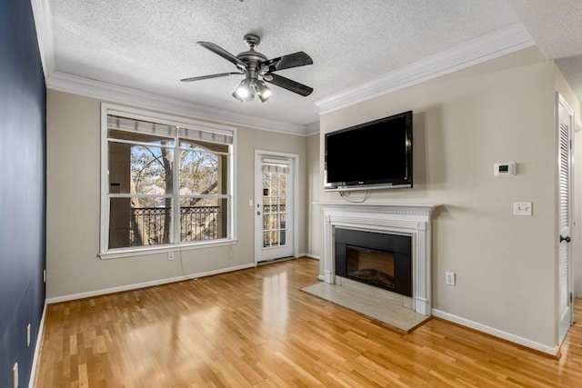 unfurnished living room with ornamental molding, wood-type flooring, ceiling fan, and a textured ceiling