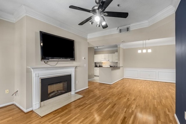 unfurnished living room featuring crown molding, ceiling fan, and light hardwood / wood-style flooring