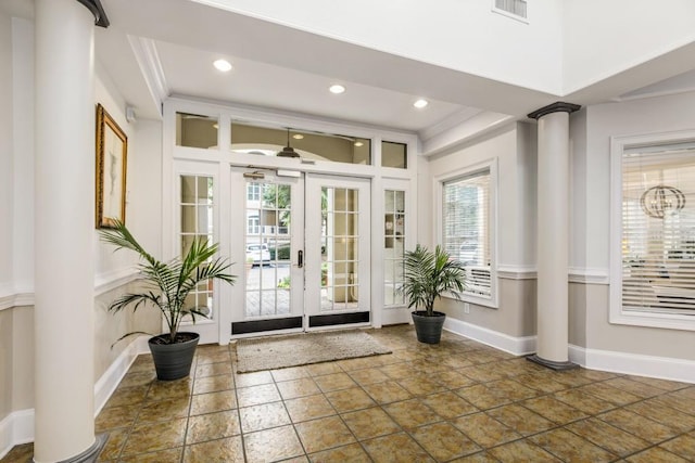 doorway to outside with ornamental molding and decorative columns