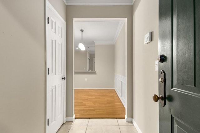 corridor featuring light tile patterned floors and ornamental molding